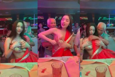 An old man squeezes a whore's boobs at a public gathering